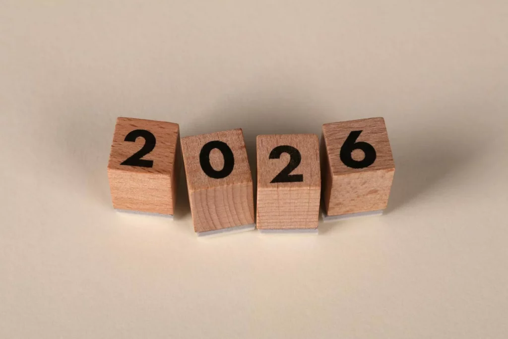 Wooden cubes forming the year 2026 on a neutral background.