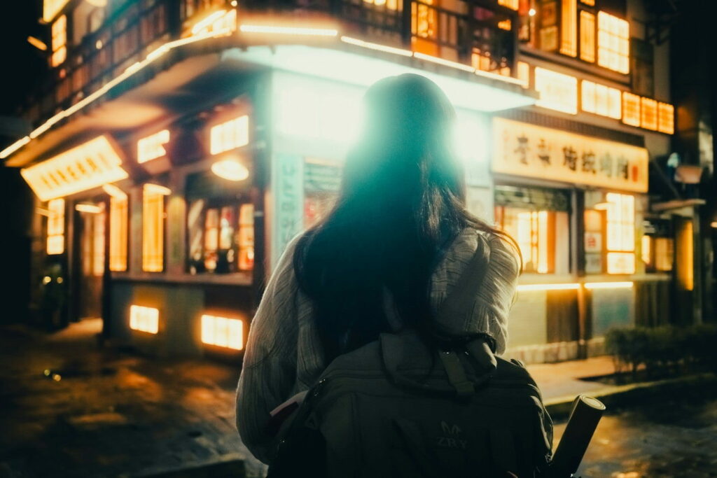 Woman walking on a wet street at night