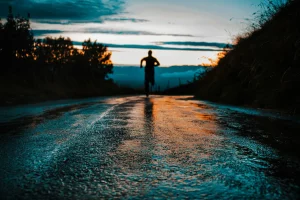 silhouette photo of a person running on road