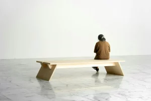 Person sitting on a long wooden bench