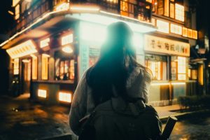 Woman walking on a wet street at night